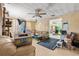 Messy living room featuring wood paneling, ceiling fan, sofa, and random furnishings at 38351 7Th Ave, Zephyrhills, FL 33542