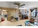 Living room with a ceiling fan, sofa, and a peek into another messy room at 38351 7Th Ave, Zephyrhills, FL 33542