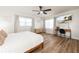 Bright bedroom with light wood floors, modern ceiling fan, and a TV above a stylish desk at 3981 Mckay Creek Dr, Largo, FL 33770