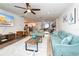 Relaxing living room with cozy seating, beach-themed decor, a ceiling fan, and wood-look flooring at 3981 Mckay Creek Dr, Largo, FL 33770