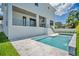 A modern white home exterior features a jacuzzi and beautiful pool with tropical landscaping at 4607 W Lamb Ave, Tampa, FL 33629