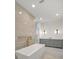 Modern bathroom featuring a soaking tub, glass-enclosed shower and grey vanity with gold hardware at 4607 W Lamb Ave, Tampa, FL 33629