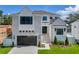 Stunning two-story home with a modern design, elegant landscaping, and a spacious driveway leading to an attached garage at 4607 W Lamb Ave, Tampa, FL 33629