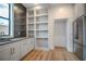 Modern kitchen features stainless refrigerator, white cabinetry, unique backsplash and built-in shelving at 4607 W Lamb Ave, Tampa, FL 33629