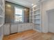 Modern kitchen features stainless appliances, white cabinetry, unique backsplash and built-in shelving at 4607 W Lamb Ave, Tampa, FL 33629