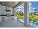 A luxurious outdoor kitchen includes stainless steel appliances and a lovely view of the tropical landscaping at 4607 W Lamb Ave, Tampa, FL 33629