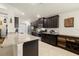 Open kitchen features dark cabinets, granite countertops, stainless steel appliances and tiled floor at 4725 Royal Birkdale Way, Wesley Chapel, FL 33543