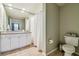 Well-lit bathroom features a white vanity, large mirror and shower with white curtain at 504 S Armenia Ave # 1338, Tampa, FL 33609