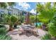 Charming outdoor patio with a dining table and chairs, surrounded by lush landscaping and tropical plants at 504 S Armenia Ave # 1338, Tampa, FL 33609