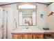 The bathroom features a vanity with sink, toilet, mirror and storage at 5428 Joyce St, Zephyrhills, FL 33542