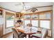 Bright dining area features large windows, ceiling fan and built-in cabinets at 5428 Joyce St, Zephyrhills, FL 33542