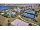 Aerial view of community amenities, including a pool, tennis courts, volleyball court, and lounging area at 5486 Summer Sunset Dr, Apollo Beach, FL 33572