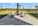 Paver patio with outdoor furniture, flowers, and lawn in a fenced backyard under a sunny sky at 5486 Summer Sunset Dr, Apollo Beach, FL 33572