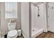 Bathroom showcasing a tiled shower, a toilet, and a bright window for natural light at 5486 Summer Sunset Dr, Apollo Beach, FL 33572