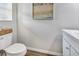 Clean half bath featuring a toilet, small vanity, and framed beachy wall art at 5486 Summer Sunset Dr, Apollo Beach, FL 33572