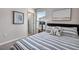 Bedroom featuring a striped bedspread, side table, and beach themed wall art at 5486 Summer Sunset Dr, Apollo Beach, FL 33572