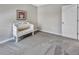 Simple bedroom with neutral carpet and a quaint decorative bench next to a door at 5486 Summer Sunset Dr, Apollo Beach, FL 33572