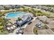 Aerial view of a community clubhouse with a lagoon pool, playground, parking and palm trees at 5486 Summer Sunset Dr, Apollo Beach, FL 33572
