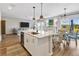 Bright, open kitchen featuring a large island, stainless steel appliances, and hardwood floors at 5486 Summer Sunset Dr, Apollo Beach, FL 33572