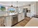 Modern kitchen with stainless steel appliances, white cabinets, and an island with countertop seating at 5486 Summer Sunset Dr, Apollo Beach, FL 33572