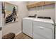 Practical laundry room equipped with a modern washer and dryer, shelving, and basket decor at 5486 Summer Sunset Dr, Apollo Beach, FL 33572
