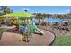 Community playground with slides and climbing structures next to a pool and seating area at 5486 Summer Sunset Dr, Apollo Beach, FL 33572