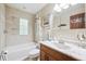 Bright bathroom with white marble vanity, tile flooring, and tub-shower combination at 6104 Schooner Way, Tampa, FL 33615