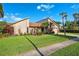 Beautifully maintained home featuring a lush green lawn and mature tropical landscaping at 6104 Schooner Way, Tampa, FL 33615