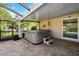 This outdoor covered patio features a relaxing hot tub and seating area, ideal for unwinding and relaxing at 6104 Schooner Way, Tampa, FL 33615
