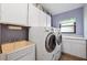 Functional laundry room with washer, dryer, utility sink, and ample cabinet space for storage at 6104 Schooner Way, Tampa, FL 33615