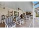 Inviting covered outdoor patio featuring comfortable seating, a ceiling fan, and a stylish bar area for entertaining at 6104 Schooner Way, Tampa, FL 33615