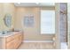 Well-lit bathroom features a large vanity, granite countertop, decorative mirror, and tiled shower at 6201 Marbella Blvd, Apollo Beach, FL 33572