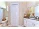 Bright bathroom with a granite vanity and white cabinet and a round window for natural light at 6201 Marbella Blvd, Apollo Beach, FL 33572