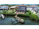 Aerial view of a two-story home featuring a boat dock and lift on a waterway at 6201 Marbella Blvd, Apollo Beach, FL 33572