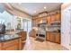 Well-lit kitchen boasts tile floors, stainless steel appliances, granite countertops, and custom cabinetry at 6201 Marbella Blvd, Apollo Beach, FL 33572