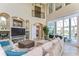 Inviting living room with a fireplace, high ceilings, and seamless access to an outdoor pool area at 6201 Marbella Blvd, Apollo Beach, FL 33572
