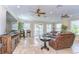 Cozy living room with travertine floors, ceiling fans, and sliding glass doors at 6201 Marbella Blvd, Apollo Beach, FL 33572