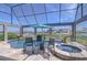 Screened pool and jacuzzi with a canal view, flowers, outside seating and an umbrella at 6201 Marbella Blvd, Apollo Beach, FL 33572