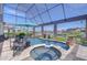 Screened pool and jacuzzi with canal views, table with seating, flowers and an umbrella at 6201 Marbella Blvd, Apollo Beach, FL 33572