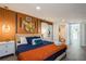 Comfortable bedroom with rustic orange accent wall and modern decor at 6225 76Th N Ave, Pinellas Park, FL 33781