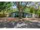 Charming single-story home featuring a blue exterior, mature trees and well kept landscaping at 6225 76Th N Ave, Pinellas Park, FL 33781