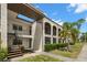 Charming condo building featuring stucco walls, arched balconies, and lush tropical landscaping at 7701 Starkey Rd # 445, Seminole, FL 33777