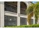 Exterior of Building 28 showing balconies and screened windows surrounded by mature tropical vegetation at 7701 Starkey Rd # 445, Seminole, FL 33777