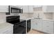 Updated kitchen features modern white cabinets, stainless steel microwave, and black appliances at 7701 Starkey Rd # 445, Seminole, FL 33777