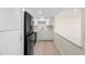 Bright kitchen featuring white cabinets, modern appliances, and wood-look floors at 7701 Starkey Rd # 445, Seminole, FL 33777