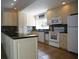 Updated kitchen featuring white cabinets, tile floors, modern appliances, and a breakfast bar at 7701 Starkey Rd # 445, Seminole, FL 33777
