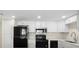 Modern kitchen featuring white cabinets, stainless steel appliances, and a black range at 7701 Starkey Rd # 445, Seminole, FL 33777