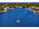 Aerial view of a boat sailing through the serene canal surrounded by waterfront homes and lush greenery at 843 37Th Ne Ave, St Petersburg, FL 33704