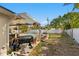 Backyard with a covered patio, outdoor kitchen, pool, fire pit, bench, and a white privacy fence at 843 37Th Ne Ave, St Petersburg, FL 33704