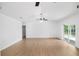 Spacious living room featuring hardwood floors, a ceiling fan, and sliding glass doors at 8513 Sunbeam Ln, Tampa, FL 33615